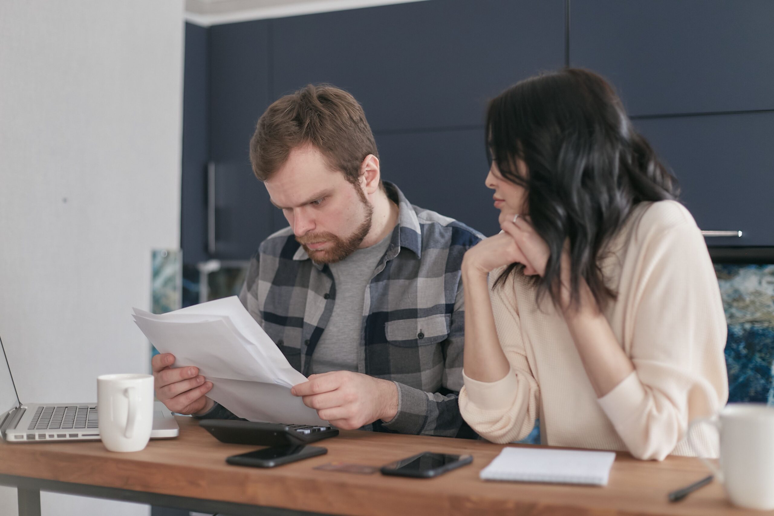 Pareja revisando documentos de la declaración de la renta en casa