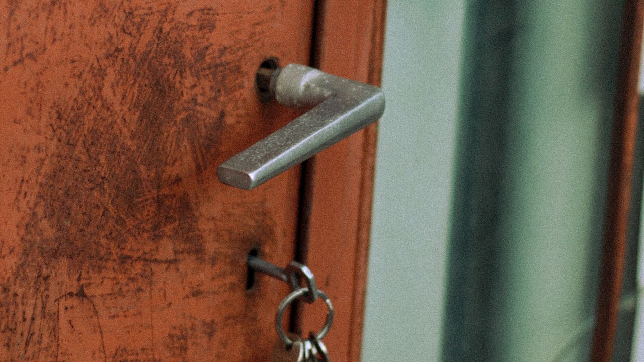 Puerta de un piso con las llaves puestas en la cerradura
